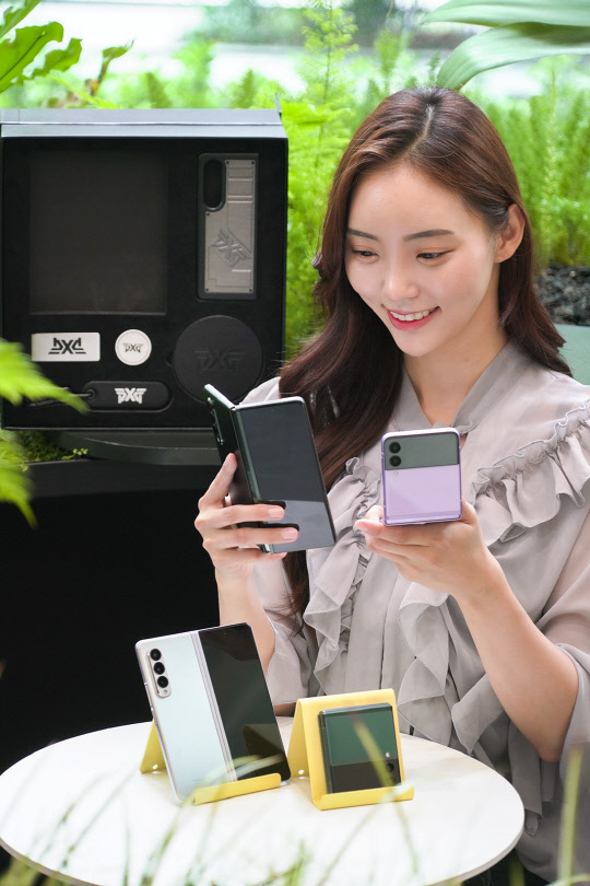 SK텔레콤 홍보모델이 T월드 매장에서 '갤럭시Z 폴드3'·'플립3' 제품을 소개하고 있다. SK텔레콤 제공